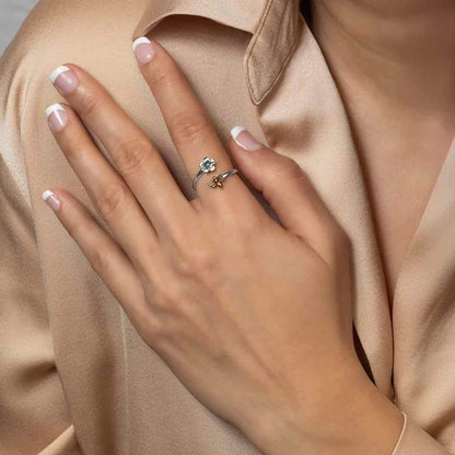 A woman's hand model wearing our petite sterling silver adjustable ring with a gold bee.  The silver band wraps around the finger with the flower and bee aligning opposite each other with an open end. 